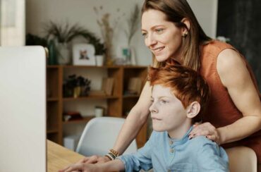 Freya has followed in her mum's footsteps and is a foster carer like her mum. Picture shows Freya helping a boy with his computer studies