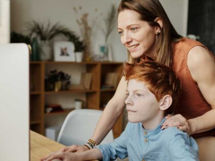 Freya has followed in her mum's footsteps and is a foster carer like her mum. Picture shows Freya helping a boy with his computer studies