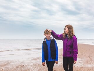 girl and boy walking on the beach