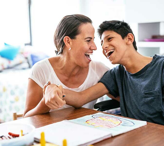 A female carer with a young person in a wheelchair