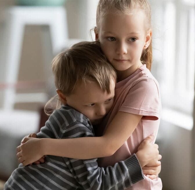 Young girl cuddling her brother