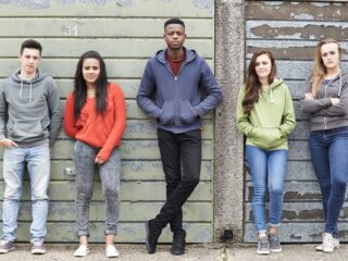 teenagers stood against a wall