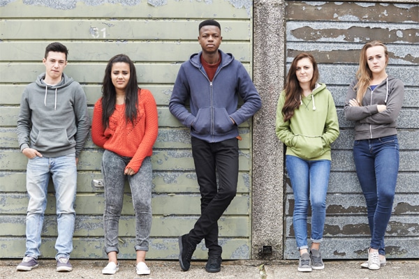 teenagers stood against a wall