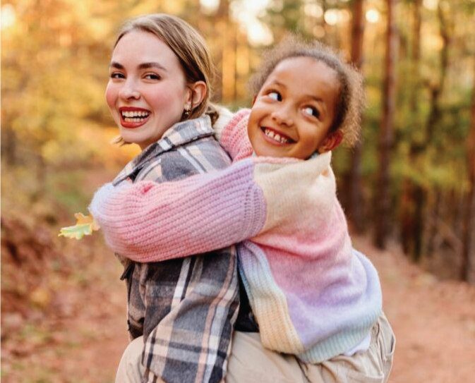 girl giving a child a piggy back