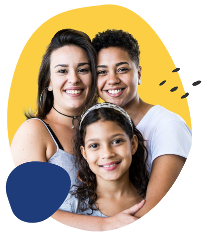 Three people smile closely at the camera in a warm group portrait. Two adults stand behind a child, with their arms around her shoulders. They are framed by a yellow abstract shape on a transparent checkerboard background, with a dark blue accent shape near the lower left and small decorative marks on the right.